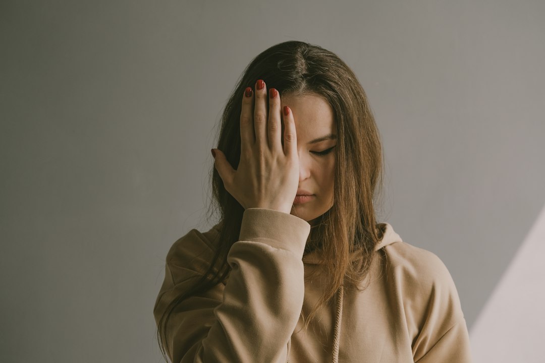Donna con le mani sul viso, mal di testa